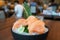 Salmon sashimi - Raw fresh salmon sliced served on black plate with wasabi and shredded radish, Hand holding chopsticks to pick