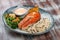 Salmon steak with cheese sauce, blanched vegetables and wild rice