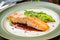 Salmon steak on the grill with avocado on plate on dark concrete table