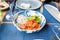 Salmon tartare with green seaweed and onion in bowl ready to share