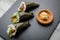 Salmon, tuna fish and Surimi avocado Temaki sushi with pickled ginger and wasabi on slate plate and marble background