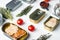 Salmon, tuna, trout mackerel and anchovy - Canned fish in tin cans, on white background with herbs and ingredients