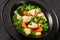 salmon, veggies and green herbs soup in bowl