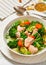 salmon, veggies and green herbs soup in bowl