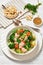 salmon, veggies and green herbs soup in bowl