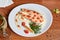 Salmon with white sauce, decorated with red caviar, cherry tomatoes, dill and a slice of lemon with red pepper