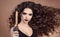 Salon Beauty. Curly hair. Close-up of brunette girl with blowing