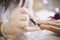 Salon manicurist applying red nail polish at salon