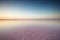 Salt and Brine of a pink lake, colored by microalgae Dunaliella salina at sunset