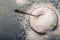 Salt. Coarse grained sea salt on granite - concrete stone background with vintage spoon and wooden bowl