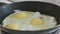 Salt fried eggs in a pan