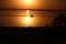 On a salt lake in the setting sun, family, father with a hat, mother and small child on the horizon with a silhouette walk along