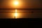 On a salt lake in the setting sun, family, father with a hat, mother and small child on the horizon with a silhouette walk along