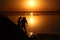 On a salt lake in the setting sun, family, father with a hat, mother and small child on the horizon with a silhouette walk along