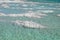 Salt ledges on the beach in the blue waters of the Dead Sea, Israel. Flakes of salt under water