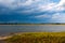 Salt marsh wetlands and distant rain storm at Assateague Island