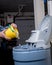 Salt pellets are poured form a yellow bucket into a blue water softener