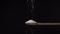 Salt poured from above into a wooden spoon isolated on a black background