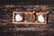 Salt, sugar and pepper set in small wooden saucer on dark wooden background