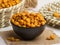 Salted corn served in a bowl isolated on napkin side view of nuts on grey background