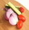 Salted cucumber, red cherry tomatoes and sliced red onion on Bamboo cutting board