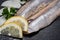 Salted Deboned Herring Fillets garnished with Yellow Onion, Lemon, Fresh Parsley and Peppercorns. Natural black stone .