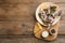 Salted herring fillets served with thyme, pickles, onion, chili pepper and lemon on wooden table, top view. Space for text