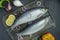 Salted herring with onions and herbs on a cutting board. Dishes from fish. Dark background. Close-up. Table background menu