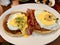 Salted Pancakes with Hollandaise Suace, Eggs and Crispy Bacon for Breakfast. Salty Organic Fast Food served at restaurant.