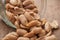 salted peanuts falling from glass container on wooden