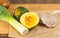 Salted and peppered raw, organic, chicken breast, washed leek, and potato, and split acorn squash, on a bamboo wood cutting board,