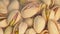 Salted pistachio nuts for beer background close up. Hot roasted pistachios rotate with stream smoke. Vegan Healthy food