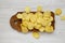 Salted wavy potato chips on a rustic wooden board on a white wooden surface, top view. Overhead, flat lay, from above