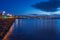 Salthill promenade waterfront before sun rise. Galway city, Ireland. Blue and orange color. Cloudy sky. Nobody. City lights and