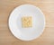 Saltine cracker on a plate atop wood table