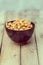Salty cashew nuts in black ceramic bowl on wood