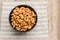 Salty cashew nuts in black ceramic bowl on wood