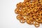 Salty cracker cookies in the shape of a pretzel sprinkled on a white background.Close-up. Texture Oktoberfest symbol