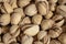 Salty delicious open pistachios in a bowl. brown natural background from natural nuts