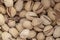 Salty delicious open pistachios in a bowl. brown natural background from natural nuts