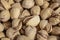 Salty delicious open pistachios in a bowl. brown natural background from natural nuts