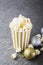 Salty fresh crusty homemade popcorn in silver paper cup in the fashion light background of white brick wall in a New
