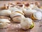 Salty pistachioes on the wooden and blurry background close up