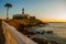 SALVADOR, BRAZIL: Sunset. Colorful sign stands in front of the colonial Farol da Barra lighthouse, the oldest in South America