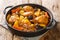 Salvadoran chicken stew with chicha, prunes, carrots, potatoes, olives and onions close-up in a frying pan. Horizontal