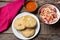 Salvadoran pupusas with coleslaw and tomato sauce on wooden background