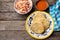 Salvadoran pupusas with coleslaw and tomato sauce on wooden background