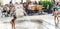 Salzburg/ Austria August 28th 2019 - Kids playing under fountain in city square with elders eating outside in summer weather and