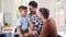 Same Sex Family With Two Dads Cooking In Kitchen With Son Sitting On Counter