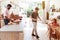 Same Sex Male Couple With Daughter Making Breakfast At Home Together